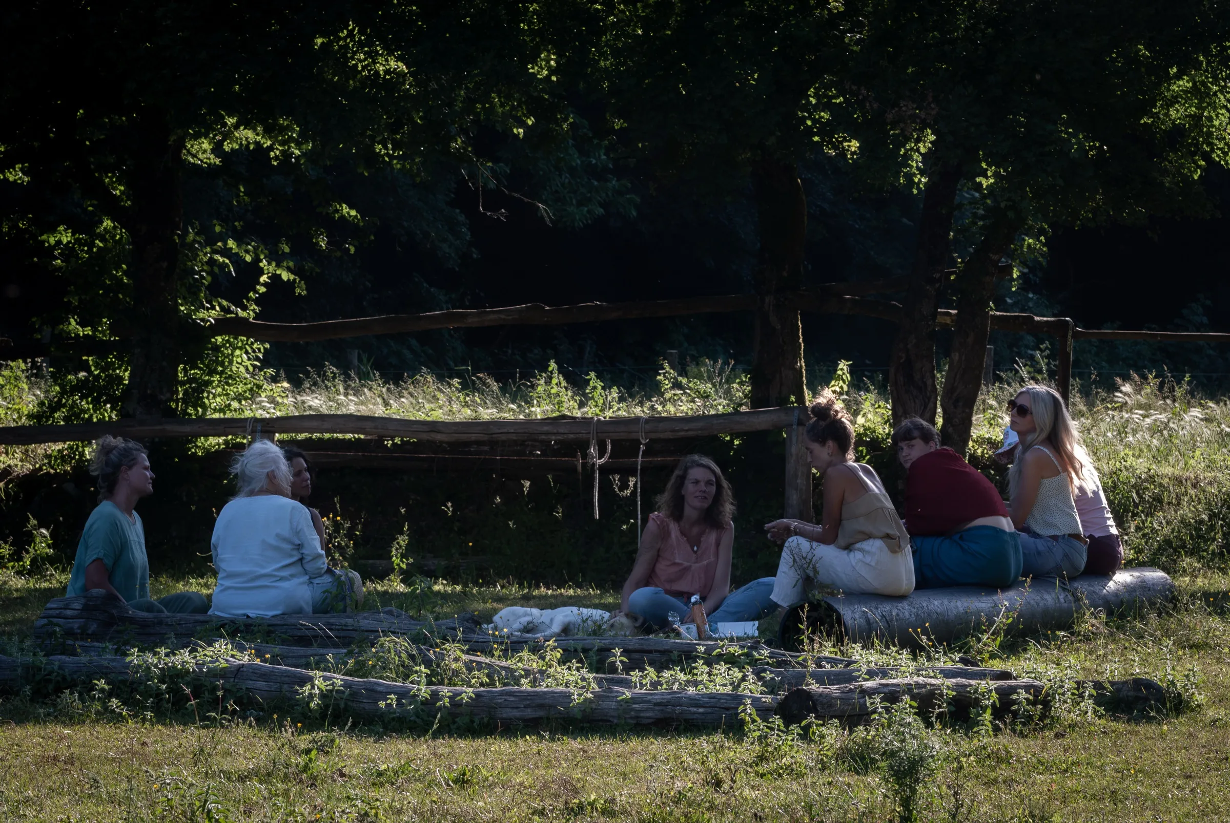 Women sitting together in a reflection circle in the golden evening light
